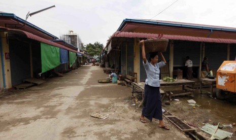   Seorang warga melintas di pasar yang sepi akibat konflik yang kembali meletus di Thandwe, Rakhine, Myanmar, Rabu (2/10).  (AP/Khin Maung Win)