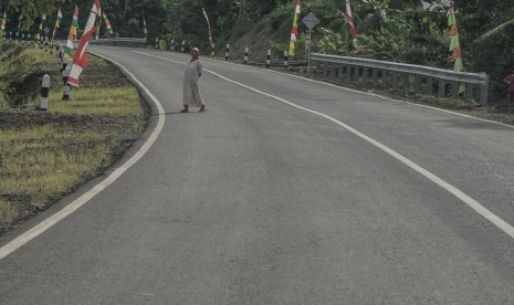 Seorang warga melintasi jalur lingkar Sumpiuh di Simpang Tambak, Banyumas, Jawa Tengah, Rabu (22/6). 