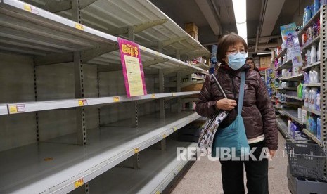 Seorang warga melintasi rak tisu yang kosong di sebuah supermarket di Hong Kong, Kamis, (6/2). Pihak berwenang Hong Kong pada Ahad (13/2/2022) mengatakan, pasokan sayuran dan unggas beku ke kota itu mungkin terganggu sementara waktu.