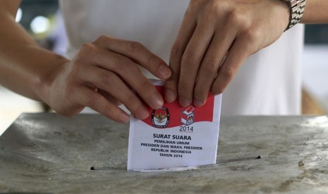  Seorang warga memasukkan kertas suara pilpres ke dalam kotak suara di Bali, Rabu (9/7).