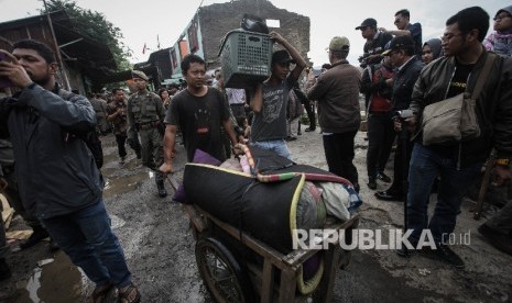 Seorang warga membawa barang bawaannya saat penggusuran di pemukiman proyek normalisasi Sungai Ciliwung, Bukit Duri, Jakarta, Rabu (28/9).