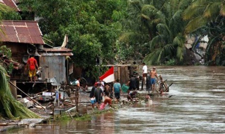 Seorang warga membersihkan lumpur rumahnya setelah terendam banjir di Manado, Sulawesi Utara, Kamis (16/1). Badan Nasional Penanggulangan Bencana (BNPB) Sulut menyatakan banjir telah menelan 15 korban, 6 di Manado , Tomohon 5 dan Minahasa 4 korban jiwa. 