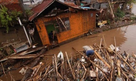 Seorang warga membersihkan lumpur rumahnya setelah terendam banjir di Manado, Sulawesi Utara, Kamis (16/1). Badan Nasional Penanggulangan Bencana (BNPB) Sulut menyatakan banjir telah menelan 15 korban, 6 di Manado , Tomohon 5 dan Minahasa 4 korban jiwa. 