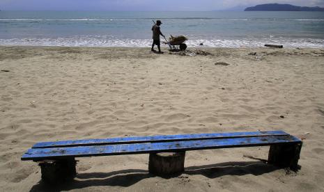 Seorang warga membersihkan sampah di Pantai Hamadi, Teluk Youtefa, Kota Jayapura, Papua, Jumat (16/9/2022).