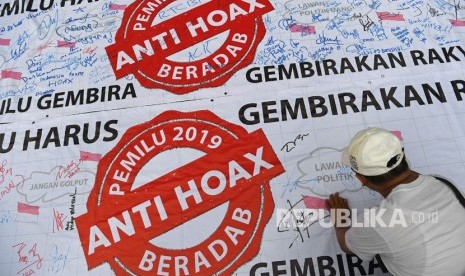 Seorang warga membubuhkan tanda tangan untuk mendukung Pemilu 2019 anti hoax saat berlangsung Hari Bebas Kendaraan Bermotor (HBKB) di Kawasan Bundaran HI Jakarta, Ahad (10/2/2019). 