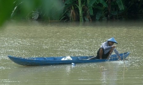 Seorang warga memeriksa jaring ikan miliknya yang ditebar di areal persawahan yang terendam air luapan dari Bengawan Solo di Desa Pelangwot, Lamongan, Jawa Timur, Senin (7/1)