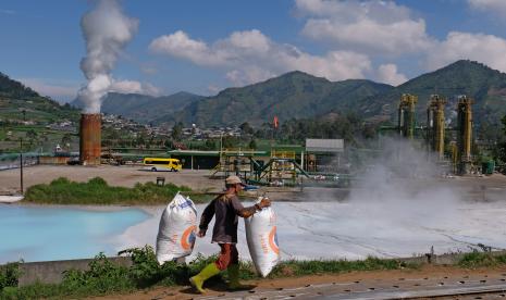 Seorang warga memikul pupuk kandang di perladangan sekitar instalasi sumur Geothermal atau panas bumi PT Geo Dipa Energi di kawasan dataran tinggi Dieng Desa Kepakisan, Batur, Banjarnegara, Jawa Tengah, Rabu (19/8). PT PLN (Persero) merealisasikan penambahan proyek pembangkit listrik energi baru terbarukan sebesar 132 megawatt hingga November 2020. 