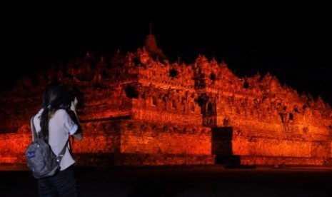 Seorang warga memotret candi Borobudur yang disinari dengan warna oranye saat berlangsung kampanye Anti Kekerasan Terhadap Perempuan di Taman Wisata Candi (TWC) Bororbudur, Magelang, Jateng, Sabtu (9/12). Kegiatan yang diselenggarakan oleh UN Women (Badan Perserikatan Bangsa-Bangsa untuk kesetaraan gender dan pemberdayaan perempuan) dengan TWC Borobudur tersebut mengusung tema 