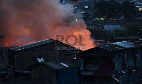 Seorang warga memotret kebakaran yang terjadi Gang Rotan, Pasar Kambing, Tanah Abang, Jakarta Pusat, Kamis (5/3). 