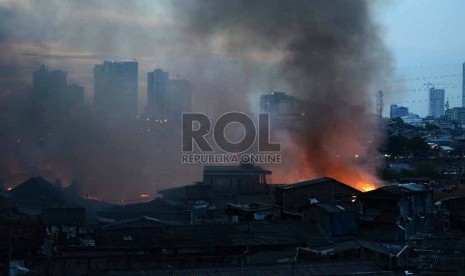 Seorang warga memotret kebakaran yang terjadi Gang Rotan, Pasar Kambing, Tanah Abang, Jakarta Pusat, Kamis (5/3). 