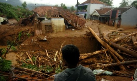 Seorang warga memperhatikan pemukiman yang terkena banjir material longsor di Desa Pasirpanjang, Salem, Brebes, Jawa Tengah, Jumat (23/2). Puluhan rumah hancur dan penuh lumpur akibat terkena material longsor bukit Gunung Lio. 