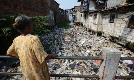  Seorang warga memperhatikan sungai yang dipenuhi sampah di Muara Baru, Jakarta utara, Selasa (19/5). 