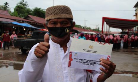 Seorang warga memperlihatkan amplop yang berisikan dana Bantuan Langsung Tunai (BLT) Minyak Goreng (ilustrasi). 