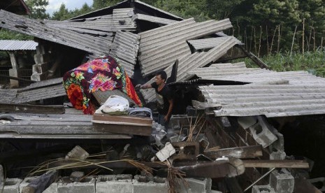 Seorang warga mengamankan kasur dari rumahnya yang hancur akibat gempa skala 6,1 SR yang menguncang Yingjiang, Provinsi Yunan, Cina, Jumat (30/5). 