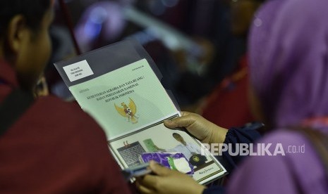 Seorang warga mengamati sertifikat tanahnya yang baru diterimanya di Sukabumi, Jawa Barat, Sabtu (7/4). 