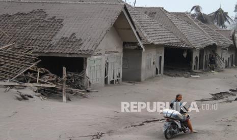 Seorang warga mengangkut barang yang bisa diselamatkan dari rumahnya yang hancur akibat erupsi gunung Semeru di desa Supiturang, Lumajang, Jawa Timur, Ahad (5/12/2021). Luncuran awan panas akibat letusan gunung Semeru mengakibatkan puluhan rumah di dua kecamatan rusak dan delapan kecamatan terdampak abu vulkanik. 