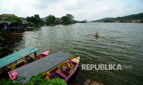 Seorang warga mengayuh perahunya di tempat wisata Situ Ciburuy, Kemacatan Padalarang, Kabupaten Bandung Barat, Kamis (29/12)