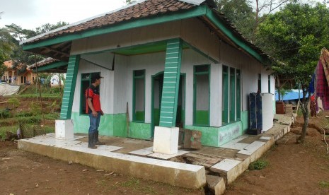 Seorang warga mengecek rumah terdampak bencana pergerakan tanah di Desa Waringinsari, Kecamatan Takokak, Cianjur, Jawa Barat, Selasa (3/10). 