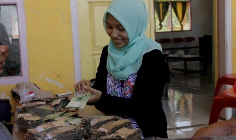 Seorang warga menggitung uang lusuh untuk ditukar dengan uang baru saat digelar Ekspedisi Kas Keliling Pulau Terluar, Terdepan dan Tertinggal (3T) di desa Tamher Timur, Pulau Kesui, Maluku, Jumat (2/11/2018).