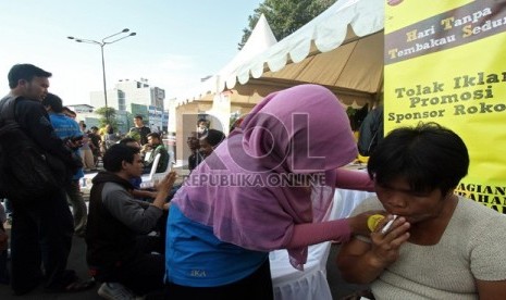 Seorang warga mengikuti terapi menghilangkan ketergantungan merokok di sekitar bundaran Hotel Indonesia, Jakarta Pusat, Ahad (2/6).  (Republika/Adhi Wicaksono)