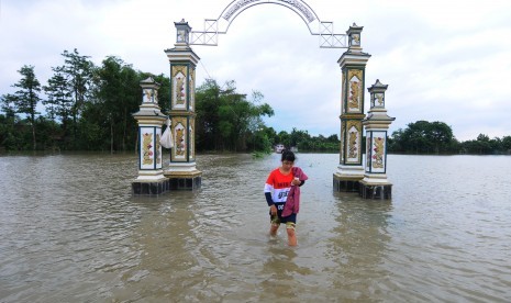 Seorang warga mengungsi akibat banjir yang melanda permukiman tempat tinggalnya di Desa Tlingsing, Cawas, Klaten, Jawa Tengah, Kamis (30/11). 