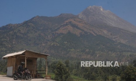 Seorang warga menikmati pemandangan Gunung Merapi di Selo, Boyolali, Jawa Tengah, Jumat (30/8/2019). 