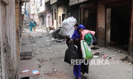 Mantan Dubes Iran untuk India Serukan Kecam Modi. Foto: Seorang warga meninggalkan lingkungan rumahnya yang hangus saat bentrok massa pendukung dan penentang UU Kewarganegaraan India berujung rusuh di New Delhi, India.