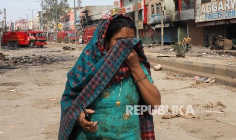 Erdogan: Orang Hindu Membantai Umat Islam di India. Foto: Seorang warga meninggalkan lingkungan rumahnya yang hangus saat bentrok massa pendukung dan penentang UU Kewarganegaraan India berujung rusuh di New Delhi, India.