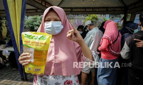 Seorang warga menunjukkan minyak goreng yang dibeli saat bazar pangan di Karawaci, Tangerang, Banten. Pemkab Tangerang mengupayakan kestabilan harga bahan pokok di bulan Ramadhan.