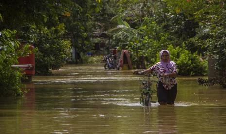 Seorang warga menuntun sepedanya melewati banjir di Desa Pajukungan, Kabupaten Hulu Sungai Tengah, Kalimantan Selatan, Rabu (17/11/2021). Sejumlah wilayah di Kabupaten Hulu Sungai Tengah masih terendam banjir dan warga merasa khawatir jika terjadi banjir susulan saat hujan deras kembali terjadi. 