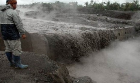 Seorang warga menyaksikan banjir lahar dingin di aliran Sungai Gendol, Bronggang, Argomulyo, Cangkringan, Sleman, Di Yogyakarta, Rabu (9/11).