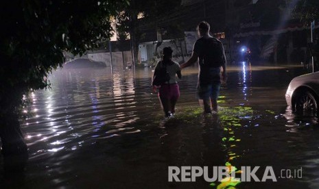 Seorang warga negara asing berjalan menembus banjir di Jalan Kemang, Ahad (28/8) dini hari. (Foto: Yogi Ardhi/Republika)