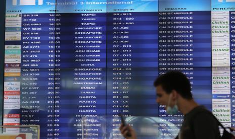 Seorang warga negara asing (WNA) berjalan di depan jadwal keberangkatan internasional di Terminal 3 Bandara Internasional Soekarno-Hatta, Tangerang, Banten.