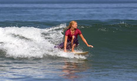 Seorang Warga negara asing (WNA) mengenakan kebaya saat mengikuti atraksi selancar di Pantai Kuta, Badung, Bali, Sabtu (16/4/2022). Atraksi selancar untuk menyambut Hari Kartini itu sekaligus sebagai daya tarik wisata guna membangkitkan pariwisata Bali yang terdampak pandemi COVID-19. 