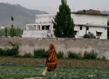 Seorang warga Pakistan melintas di depan bekas tempat tinggal Usamah bin Ladin di Abbottabad.