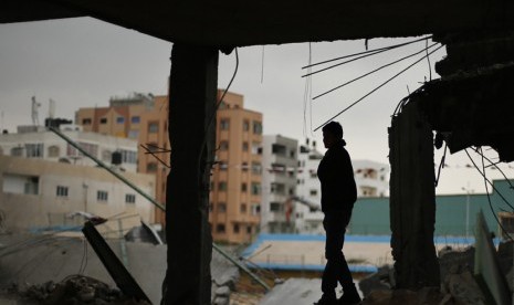  Seorang warga Palestina berdiri diatas reruntuhan stadion sepak bola, yang hancur akibat serangan udara Israel selama konflik delapan hari di Kota Gaza,Selasa (4/12).  (Reuters/Suhaib Salem)