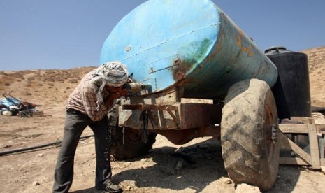 Seorang warga Palestina  yang tinggal di Area C, Tepi Barat, meminum air langsung dari tangki penyimpanan air. Israel membatasi bahkan meniadakan akses ke sumber-sumber alam untuk warga Palestina di kawasan tersebut