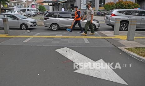 Seorang warga pelanggar protokol kesehatan mendapat sanksi sosial berupa menyapu jalan. ilustrasi