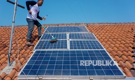 Seorang warga pemilik panel surya, Agus Nurokhim, membersihkan panel Pembangkit Listrik Tenaga Surya (PLTS) di atap rumahnya di Sragi, Kabupaten Pekalongan, Jawa Tengah, Ahad (1/9).  Kementerian Energi dan Sumber Daya Mineral (ESDM) mencatat hingga semester I tahun ini sebanyak 2.346 pelanggan PLN sudah memasang Pembangkit Listrik Tenaga Surya (PLTS) Atap. 