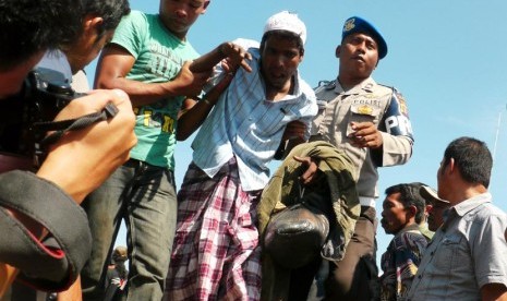  Seorang warga Rohingya dalam kondisi lemah dibantu warga turun dari kapal usai dievakuasi dari Pulau Aceh, saat tiba di Pelabuhan Lampulo, Banda Aceh, Senin (8/4).  (Antara/Ampelsa)