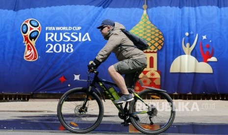 Seorang warga Rusia mengendarai sepeda di depan logo Piala Dunia 2018 di Moskow, Rusia, Rabu  (6/6).Piala Dunia 2018 akan berlangsung di Rusia dari 14 Juni hingga 15 Juli 2018. 