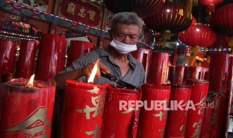 Seorang warga Tionghoa membersihkan lilin sembahyang di Kelenteng Tri Dharma Dwi Dharma Bhakti, di Pontianak, Kalimantan Barat, Senin (14/2/2022). Kegiatan tersebut sebagai persiapan untuk mengakhiri masa perayaan Tahun Baru Imlek dan menyambut Cap Go Meh yang jatuh pada Selasa (15/2/2022).