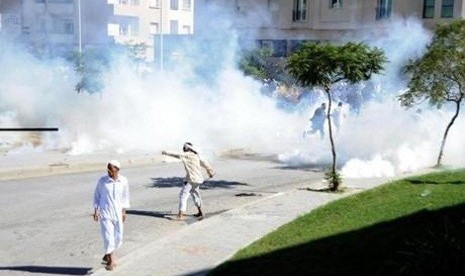 Seorang warga Tunisia melempar batu dalam aksi protes di depan Kedutaan Besar AS di Tunis, Jumat (14/9/2012)