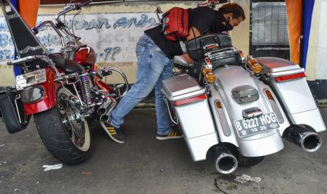 Seorang wartawan melihat barang bukti dua motor gede (moge) di Mako Polres Ciamis, Kabupaten Ciamis, Jawa Barat, Senin (14/3/2022). Satuan Lalu Lintas Polres Ciamis mengamankan dua unit motor gede (moge) Harley Davidson yang menewaskan dua anak kembar bernama Hasan dan Husen di Jalan Raya Kalipucang-Pangandaran, Desa Tunggilis, Kecamatan Kalipucang, Kabupaten Pangandaran, pada Sabtu (12/3) dan pihak kepolisian tidak melakukan penahanan terhadap pelaku.