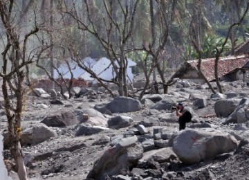  Seorang wisatawan asing memotret suasana desa mati di hamparan pasir bekas permukiman warga Dusun Gempol, Jumoyo, Salam, Magelang, Jateng. 