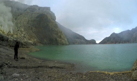 Seorang wisatawan lokal mengambil gambar Danau Kawah Ijen di Cagar Alam Taman Wisata Ijen, Kecamatan Licin, Banyuwangi, Jawa Timur, Minggu (13/11). 