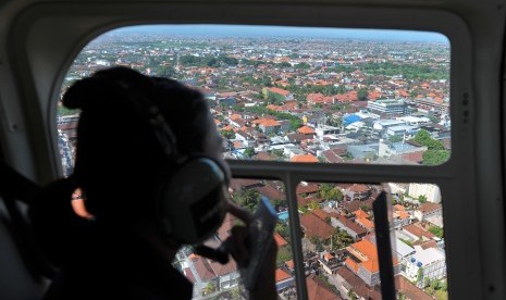 Seorang wisatawan menikmati pemandangan Bali dari udara. Ilustrasi