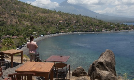 Seorang wisatawan menikmati pemandangan di Pantai Desa Amed, Karangasem, Bali (ilustrasi)