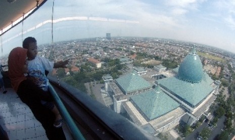 Seorang wisatawan menyaksikan panorama dari atas menara Masjid Al-Akbar Surabaya (MAS), Surabaya, Jawa Timur.