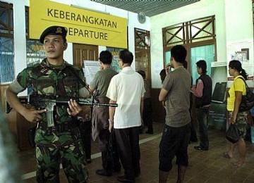 Seorang anggota TNI AD dari Yon 642 Kapuas siaga di samping barisan sejumlah pelintas batas di pintu lintas batas atau PLB (border line) Indonesia-Sarawak Malaysia, Entikong, Kalbar.